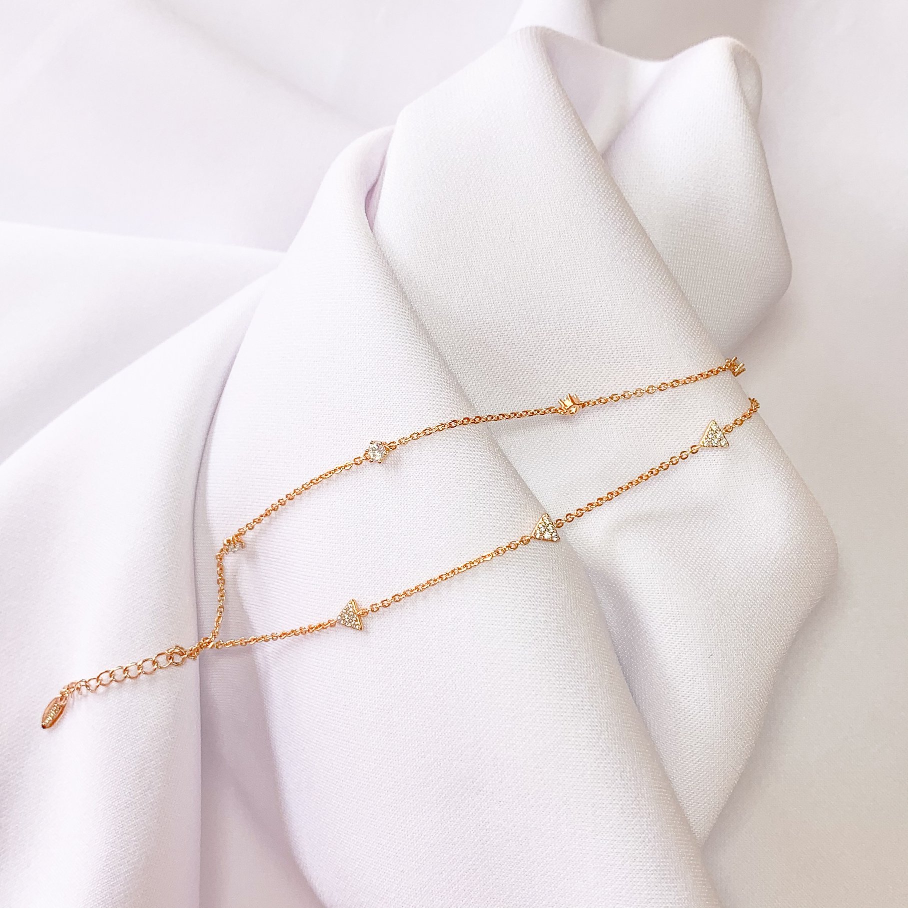 Photo of a Gold Necklace on a White Cloth